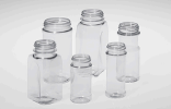 Collection of empty glass jars of varying heights on a light background.