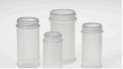 Four empty clear glass jars with metal screw-on lids of varying heights on a light gray background.