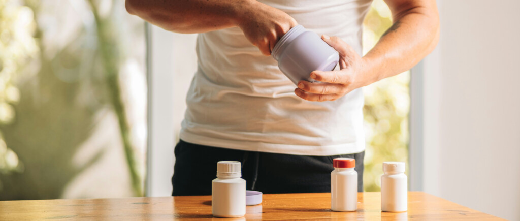 A fit man opens jars containing nutrition and wellness products